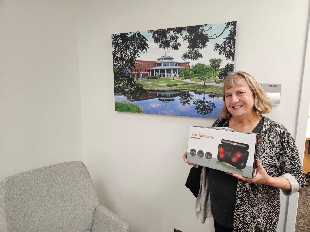 Photo of session 1 walking club winner holding massage gun prize