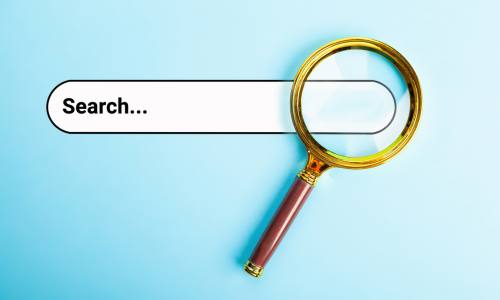 A magnifying glass poised over one end of a search box.