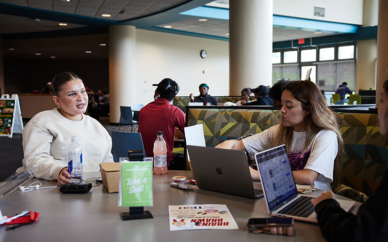 Students around a table in the Nosh