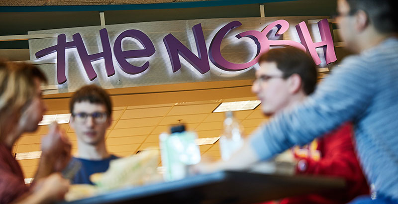 Students in front of the Nosh sign