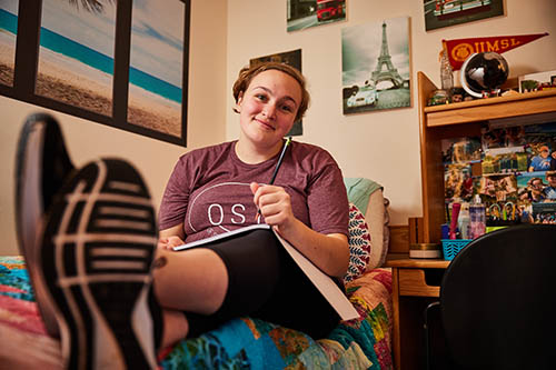 student with a notebook in their dorm room