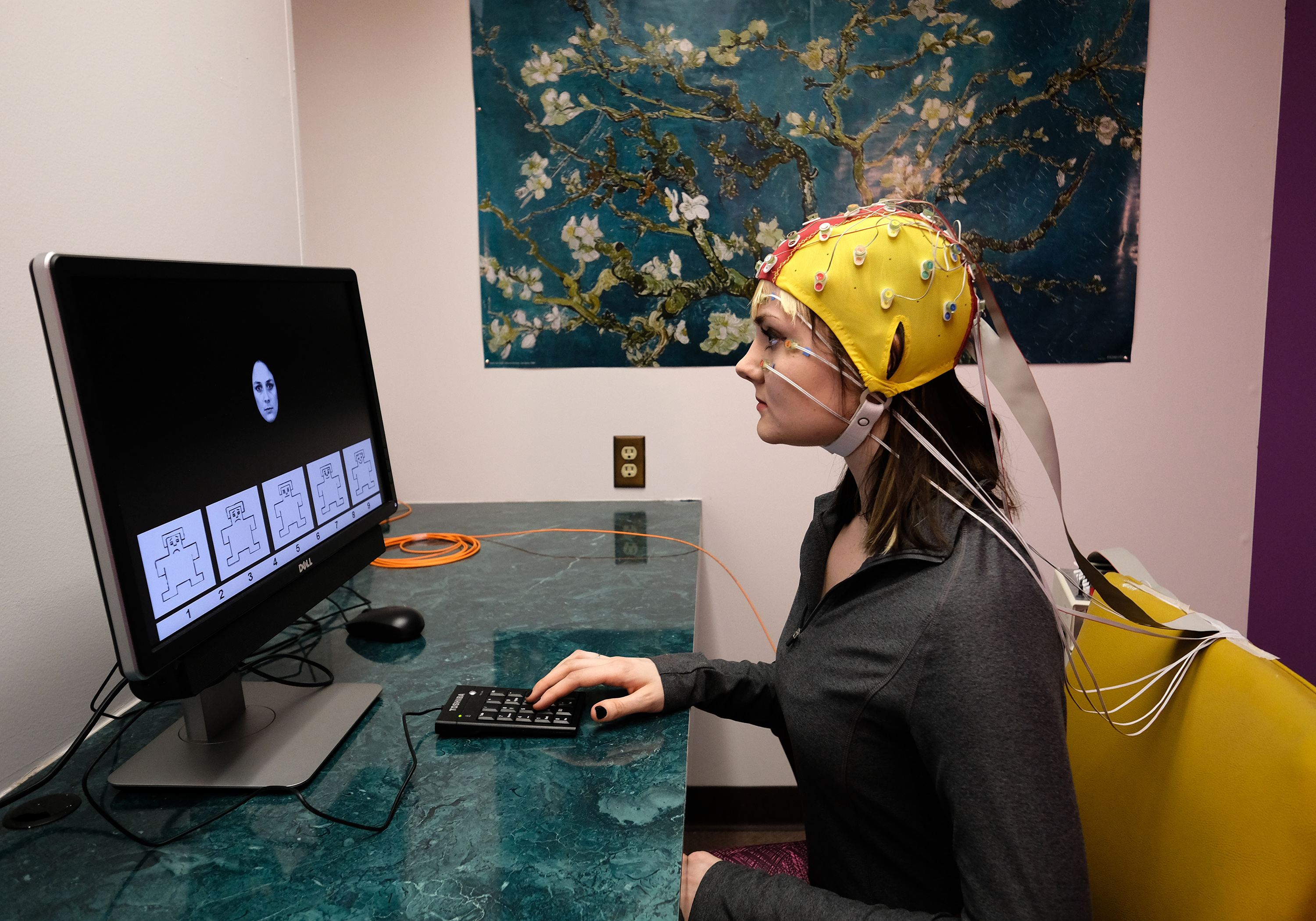 student at a computer with a helmet on