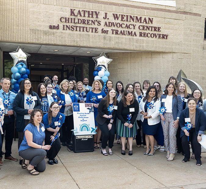 group photo of staff under the Weinman Center sign