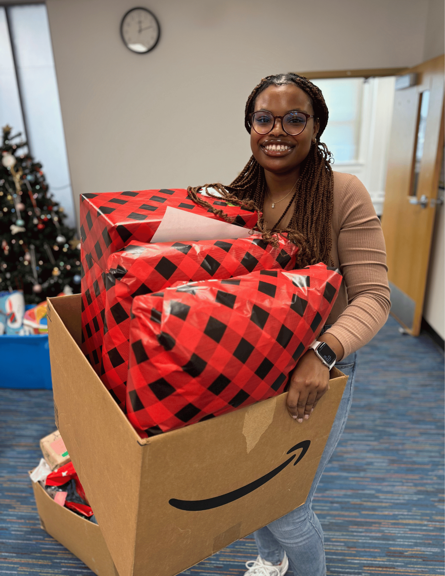 Student Latrice Wilson holding a box of wrapped gifts