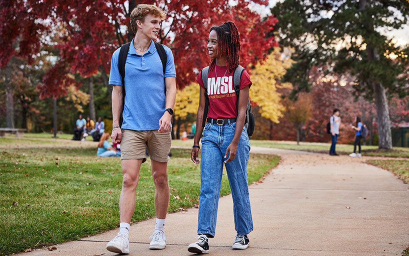 Two students walking along the path towards the Mercantile library