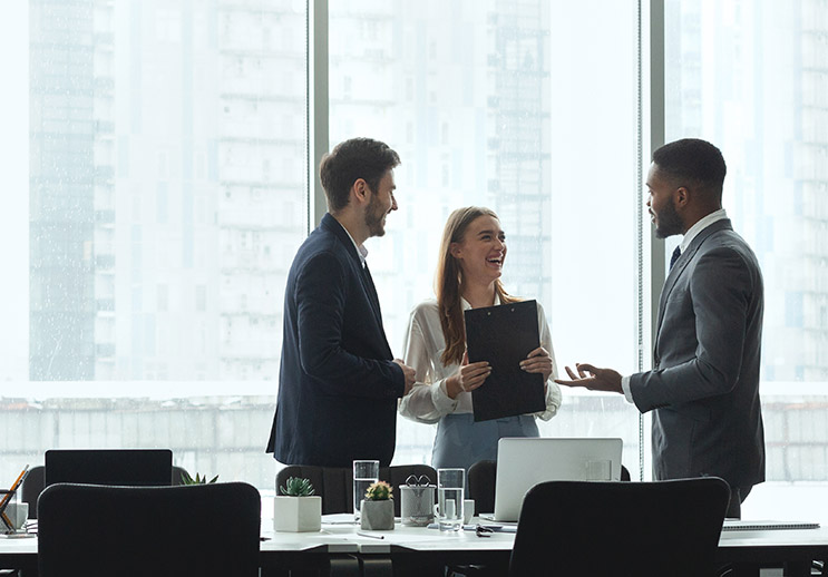 three people in suits in a corporate board room