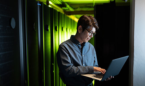 man standing with laptop