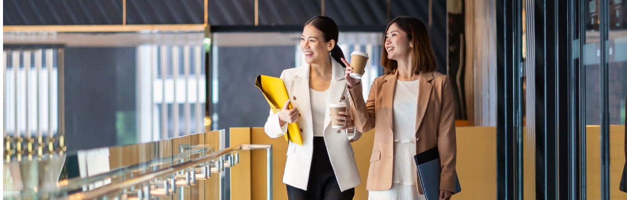 Two women walking in office space