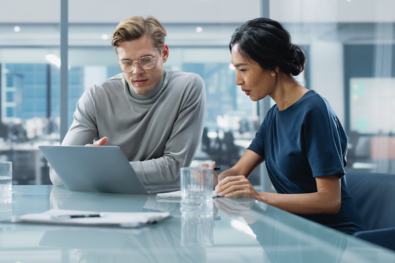 A group of four professionals engaged in a discussion in a modern office setting.