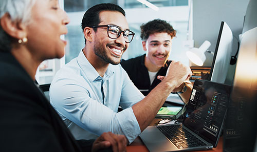 three people in a business setting looking at computer monitors
