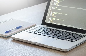 Picture of laptop with notebook and pen