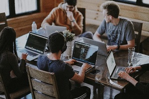 Group of learners with laptops working at a table on Power BI data analysis
