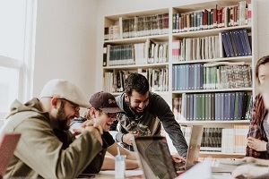 Picture of students at table looking at laptop screen